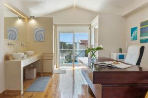 een badkamer met een bureau en een wastafel bij Beach Family Villa in Artemida in Artemida +32 foto's