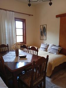 a dining room with a table and a bed at Aris house in Vília