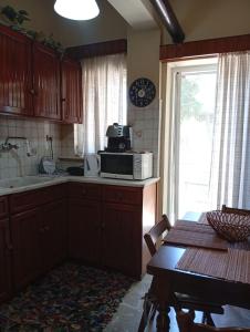 a kitchen with a microwave and a table and a window at Aris house in Vília +14 photos