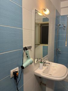 a bathroom with a sink and a mirror at Diego Rooms Vlora in Vlorë +10 photos