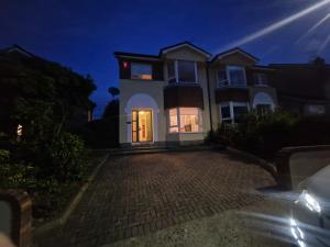 a large white house at night with a driveway at 19 college Green in Wexford