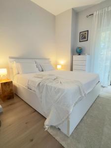 a white bedroom with a large white bed and a window at La Terrazza Sulla Valle in Sgurgola