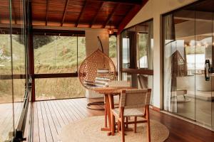 a room with a wooden table and a swing at Turisfri Resort in Nova Friburgo