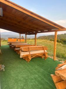 a group of wooden benches on a green field at Petrovf Place in Daljan