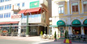 a group of buildings on a street with tables and chairs at Torget Aparthotel in Pori