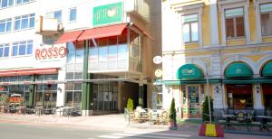 een groep gebouwen op een straat met tafels en stoelen bij Torget Aparthotel in Pori