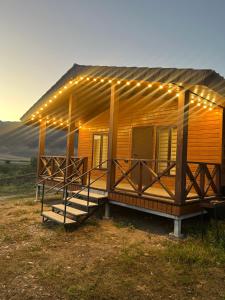 a wooden cabin with lights on the front of it at Kolsay Domik in Kurmenty