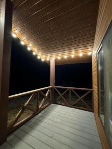 a patio with lights on a wooden deck at Kolsay Domik in Kurmenty +1 photo
