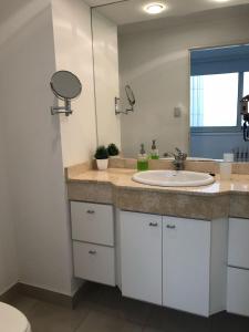 a bathroom with a sink and a mirror at Increible departamento con vista panoramica en primera linea del mar in Monte Hermoso