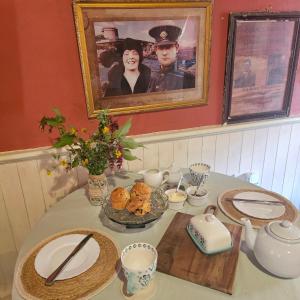 ein Tisch mit Tellern und einem Bild von einem Mann und einer Frau in der Unterkunft Longford Holiday Kitty Kiernan's Self Catering Thatch Cottage in Longford