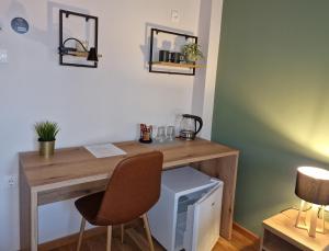 escritorio de madera con ordenador y 2 sillas en Apartmani i sobe PARK, en Apatin