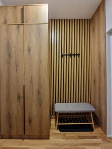Un banco junto a un armario de madera. en Apartmani i sobe PARK, en Apatin 77 fotos más