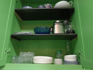 Sidi Yahia az ZaʼerにあるGreen houseの皿やカップ、食器が入った緑色のキャビネット