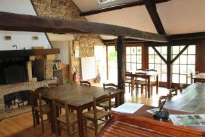 a dining room with a table and chairs and a fireplace at Le moulin de vaux in Nochizé