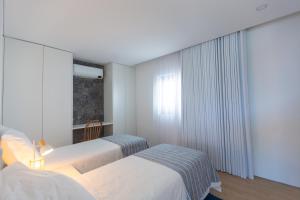 a hotel room with two beds and a window at Casa Mare in Lagoa