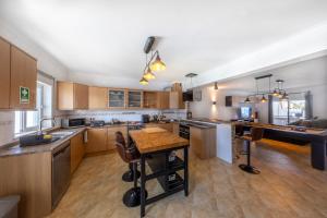 a large kitchen with wooden cabinets and a table at Sagres ZEN - 3 Bedroom House in Sagres