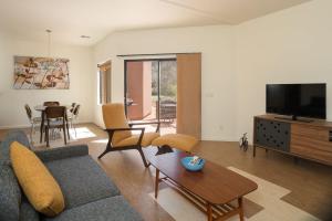 セドナにあるEco-Friendly Townhome in Sedona Natureのソファ、テレビ、テーブルのあるリビングルーム