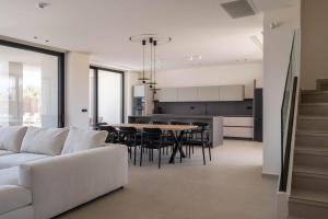 a living room with a white couch and a table at Gemini Villas - Villa Calma & Siesta in Maleme