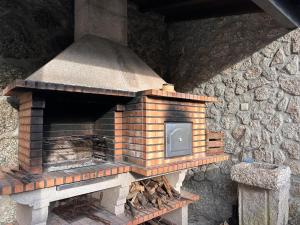 an outdoor brick oven sitting next to a stone wall at Casa da Forja - Gerês in Gondoriz