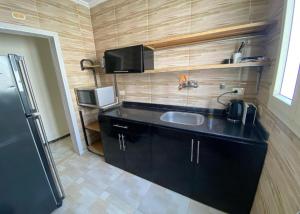a small kitchen with a sink and a refrigerator at Hayah Suites & Rooms in Alexandria
