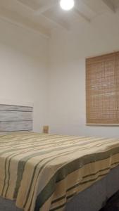 a bedroom with a large bed in a white room at Aire de lavandas in La Paz