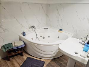 a white bathroom with a tub and a sink at B&B Al 17 in Sturno