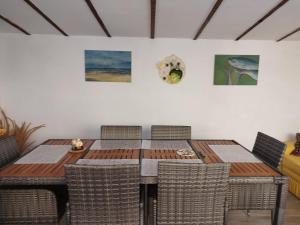 a dining room table with chairs and paintings on the wall at Casa Ancora Sulina in Sulina