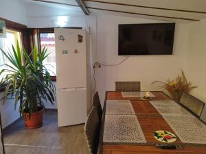 a dining room with a table and a refrigerator at Casa Ancora Sulina in Sulina