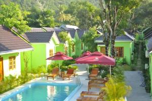 ein Resort mit einem Swimmingpool mit Stühlen und Sonnenschirmen in der Unterkunft Bamboo Resort Phu Quoc in Phu Quoc