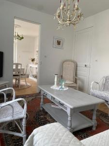 ランにあるAgréable maison style shabby chicのテーブルと椅子2脚のあるリビングルーム