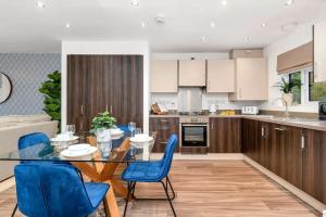 a kitchen with a dining table and blue chairs at NEW Berkley House by Truestays - 3 Bedroom House in Stoke-on-Trent in Etruria