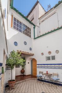 einen Innenhof eines Gebäudes mit einem Tisch und Stühlen in der Unterkunft Calleja La Pimentera in Córdoba