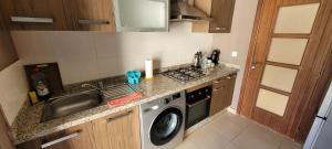 a small kitchen with a sink and a washing machine at Apartment Close to Casablanca Mohamed V Airport in Nouaseur