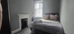 a bedroom with a bed with a fireplace and a window at Stylish 4 bed in Central Conwy in Conwy