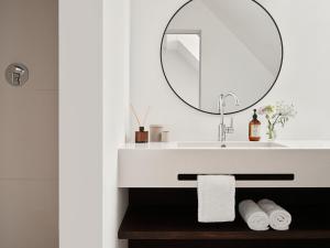 a bathroom with a sink and a mirror at Bob W Munich Schwabing in Munich