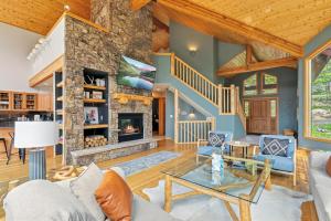 Una sala de estar con chimenea de piedra en una casa. en Breckenridge Retreat Hot Tub and Mountain Vistas, en Breckenridge