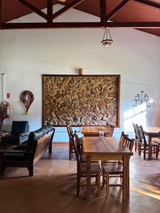 a dining room with a table and chairs and a stone wall at Pousada Villa Verona in Serra Negra