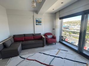 a living room with a couch and a red chair at Vista Marina Çeşme in Çeşme