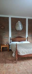 a bedroom with a bed and a brick wall at Finca Eco Turística Aguas del Arenal 