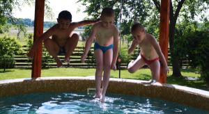 un grupo de niños saltando a una piscina en Tisza-Kert Vendégház -Tisza-Kert Vendégház II, en Tiszafüred