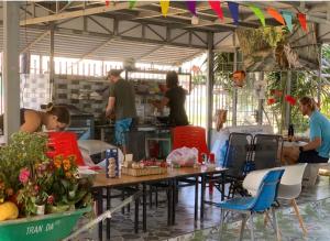 a group of people in a kitchen with tables and chairs at Nomad homestay in Ninh Hải