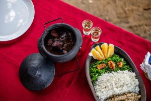 a table with a plate of food and a bowl of rice at Pousada da Janjana in Nova Iguaçu +52 photos