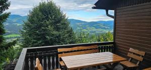 a wooden bench on a balcony with a view of mountains at Ferienhaus Anna in Weitenbach