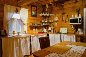 een keuken met houten wanden en een tafel en een aanrecht bij Chata Łońska in Pultusk +11 foto's