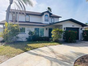 a house with a palm tree and a driveway at 4 Bedroom home with heated pool by the beach! in Clearwater Beach