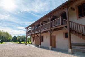 a building with a balcony with people on it at Hotel Village Motel in Tournus