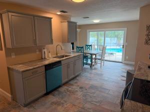 a kitchen with a sink and a dining room with a table at 4 Bedroom home with heated pool by the beach! in Clearwater Beach