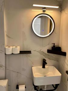 a white bathroom with a sink and a mirror at Halkidiki Beach House AELIA in Skála Foúrkas