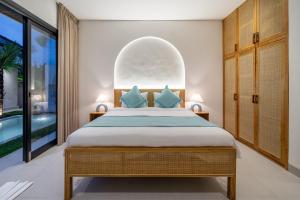 a bedroom with a bed and a large window at Ferreno Villa - Family-Friendly Designer Villa- Private Pool - Central in Kerobokan