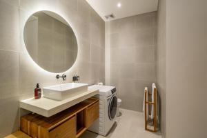 a bathroom with a sink and a washing machine at Ferreno Villa - Family-Friendly Designer Villa- Private Pool - Central in Kerobokan +6 photos